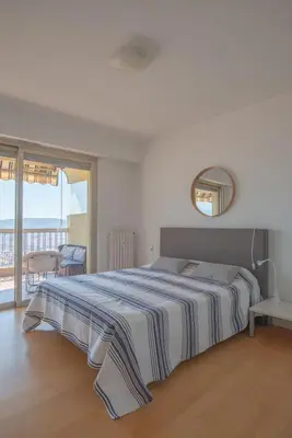 a bedroom with a large bed and a balcony at 3 pièces vue mer et piscine quartier Parc Impérial in Nice