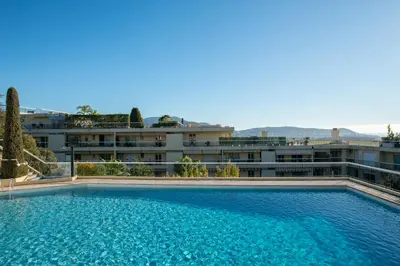a large swimming pool in front of a building at 3 pièces vue mer et piscine quartier Parc Impérial in Nice