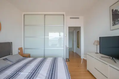 a bedroom with a bed and a flat screen tv at 3 pièces vue mer et piscine quartier Parc Impérial in Nice