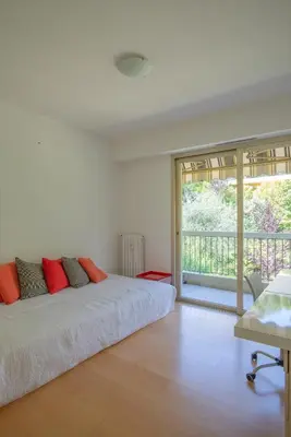 a white bedroom with a bed and a balcony at 3 pièces vue mer et piscine quartier Parc Impérial in Nice