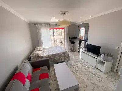a living room with a couch and a television at Stylish Modern Beach Studio in Nice