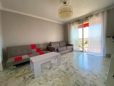 a living room with a couch and a table at Stylish Modern Beach Studio in Nice