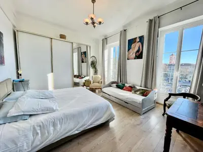 a bedroom with a bed and a couch and windows at Spacious 3 BR flat Nice center - magnificent view in Nice