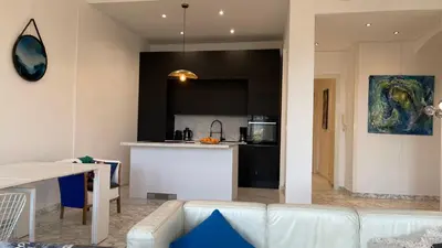 a living room with a white couch and a kitchen at Spacious 3 BR flat Nice center - magnificent view in Nice