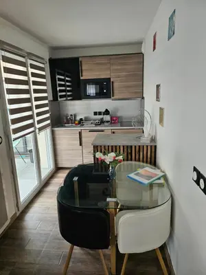 a living room with a glass table and a kitchen at Nice, là côté magique in Nice