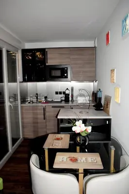 a kitchen with a table and chairs in a room at Nice, là côté magique in Nice