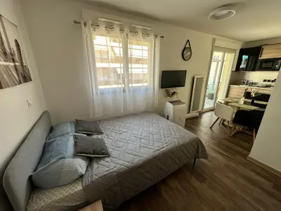 a bedroom with a bed and a desk in it at Nice, là côté magique in Nice