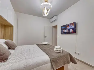 a bedroom with a large bed and a tv on the wall at City Vibes, Indoor Parking, Breakfast & Air Conditioning in Nice