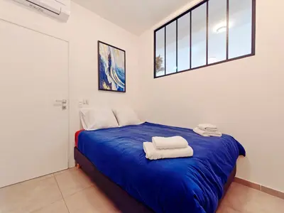 a bedroom with a blue bed with towels on it at City Vibes, Indoor Parking, Breakfast & Air Conditioning in Nice