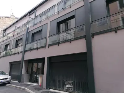 an apartment building with two garage doors and a balcony at City Vibes, Indoor Parking, Breakfast & Air Conditioning in Nice
