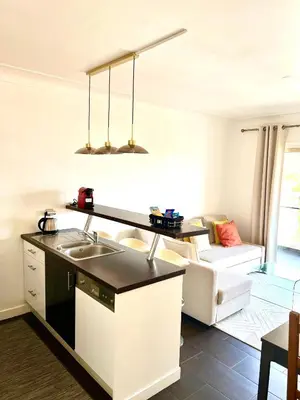 a kitchen with a sink and a living room at Beaulieu Sur Mer: Superbe Appart avec vue Mer in Beaulieu-sur-Mer