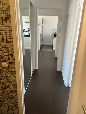a hallway with a mirror and a tile floor at Beaulieu Sur Mer: Superbe Appart avec vue Mer in Beaulieu-sur-Mer