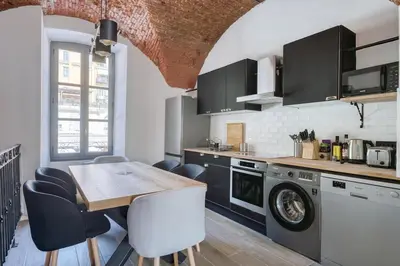 a kitchen with a table and a washer and dryer at Superbe Appartement Au Coeur du Vieux Nice ! in Nice