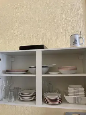 a white shelf with plates and dishes on it at Appartement au centre de Nice in Nice