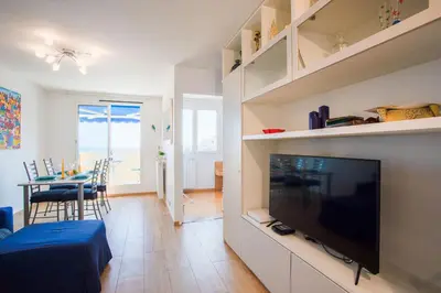 a living room with a large television and a dining room at Passy Azur AP4242 by Riviera Holiday Homes in Nice
