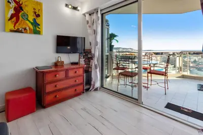 a living room with a television and a sliding glass door at La Coquette - Sea View - Parking - AC - Pool in Nice