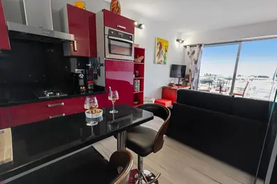 a kitchen with a bar with two glasses of wine at La Coquette - Sea View - Parking - AC - Pool in Nice