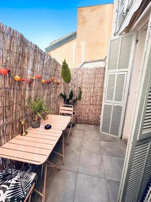 a patio with a wooden table and a fence at Studio Cocooning avec terrasse au calme Quartier Les Musiciens Mer à 7 minutes à pieds in Nice