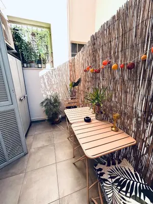 a patio with a wooden table and a fence at Studio Cocooning avec terrasse au calme Quartier Les Musiciens Mer à 7 minutes à pieds in Nice