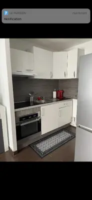 a kitchen with white cabinets and a stove top oven at Appartement avec piscine privée in Cagnes-sur-Mer