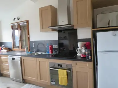 a kitchen with wooden cabinets and a stove top oven at 2P entre mer et montagne in Gattières
