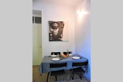 a blue table with chairs and a painting on the wall at 2 spacious bedrooms near Riquier station! in Nice