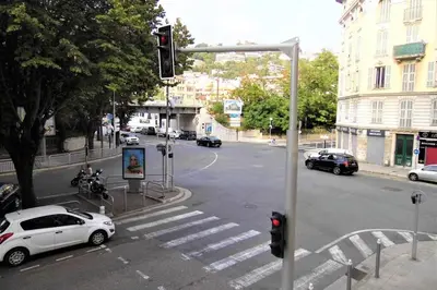 a white car parked at an intersection with a traffic light at 2 spacious bedrooms near Riquier station! in Nice