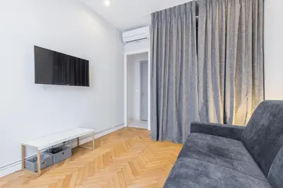 a living room with a couch and a tv at Open Sky Terrace Downtown Studio in Nice