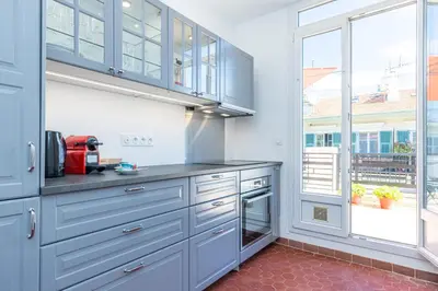 a kitchen with blue cabinets and a large window at Open Sky Terrace Downtown Studio in Nice
