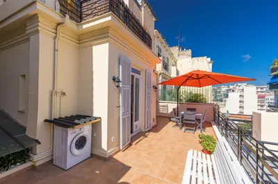 a balcony with a washing machine and an umbrella at Open Sky Terrace Downtown Studio in Nice