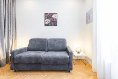 a blue couch in a living room with a table at Open Sky Terrace Downtown Studio in Nice