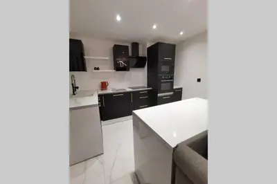 a kitchen with black cabinets and a white counter top at Nid d'amour baignoire/jacuzzi in Nice