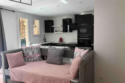 a living room with a couch and a kitchen at Nid d'amour baignoire/jacuzzi in Nice