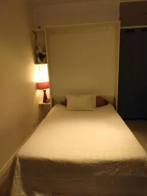 a small bedroom with a white bed with a lamp at NICE- GAIRAUT - JARDIN PRIVE- GRAND F1 LUMINEUX-Piscine Collective in Nice