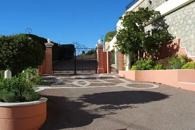 an entrance to a house with a black gate at Stunning Penthouse with panoramic views of Eze Village and the French Riviera in Èze