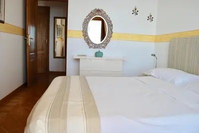 a bedroom with a white bed and a mirror at Stunning Penthouse with panoramic views of Eze Village and the French Riviera in Èze