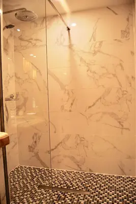 a bathroom with a shower with a marble wall at Stunning Penthouse with panoramic views of Eze Village and the French Riviera in Èze