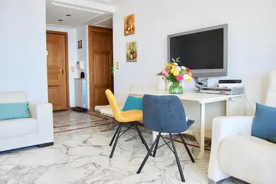 a living room with a desk with a tv and chairs at Stunning Penthouse with panoramic views of Eze Village and the French Riviera in Èze