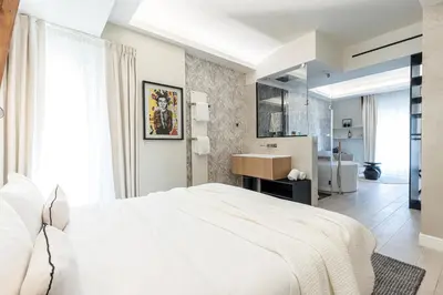 a bedroom with a white bed and a sink at Le Dortoir Boutique Suites in Nice