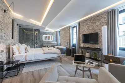 a bedroom with a bed and a living room at Le Dortoir Boutique Suites in Nice