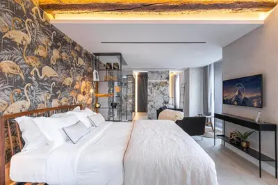 a bedroom with a large white bed and a wall mural at Le Dortoir Boutique Suites in Nice