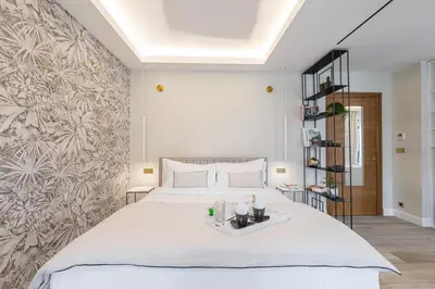 a bedroom with a large white bed and a wall at Le Dortoir Boutique Suites in Nice