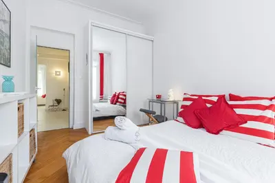 a bedroom with two beds with red and white pillows at FEEL HOME - GRIMALDI in Nice