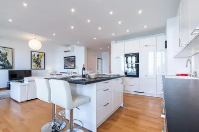 a kitchen with white cabinets and a counter top at Sea View Large 2 Bdr Promenade des Anglais in Nice