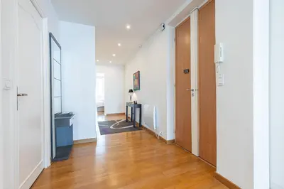 a hallway with white walls and a wooden door at Sea View Large 2 Bdr Promenade des Anglais in Nice