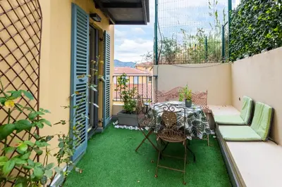 a patio with green grass and a table and chairs at La Providence in Nice