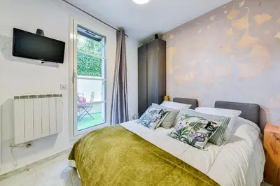 a bedroom with a bed with a tv on the wall at La Providence in Nice