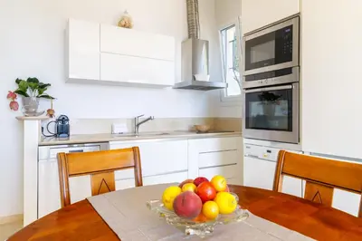 a kitchen with a table with a bowl of fruit at Sea View Apartment with Private Secure Parking 1 in Villefranche-sur-Mer
