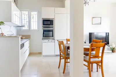 a kitchen with white cabinets and a table and chairs at Sea View Apartment with Private Secure Parking 1 in Villefranche-sur-Mer