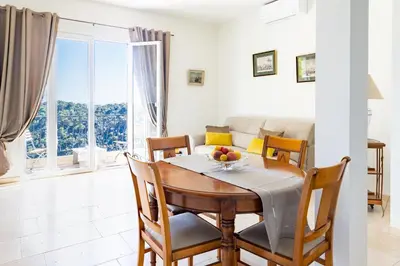 a dining room with a table and chairs and a couch at Sea View Apartment with Private Secure Parking 1 in Villefranche-sur-Mer
